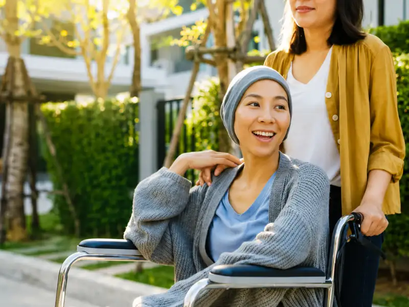 Woman recovering from cancer with caregiver support, representing cancer insurance protection.