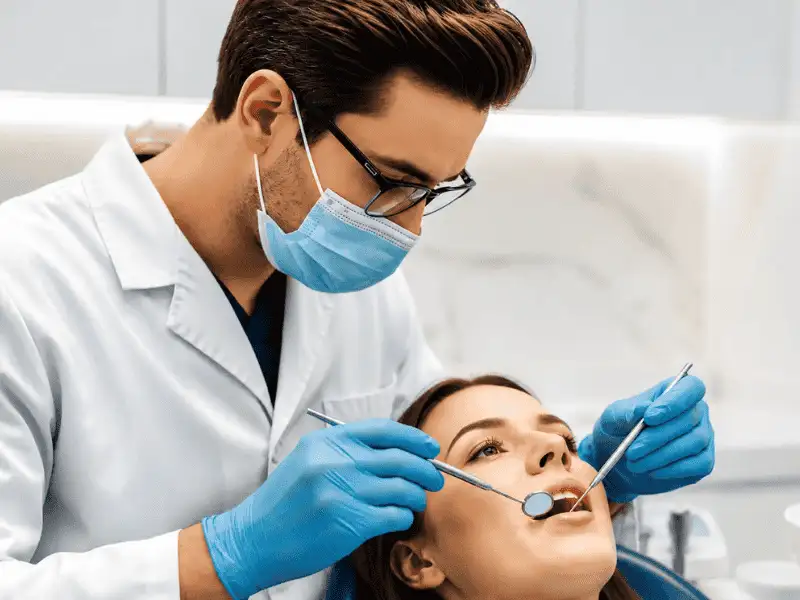 Dentist providing a dental examination to a patient during a routine dental insurance covered visit.