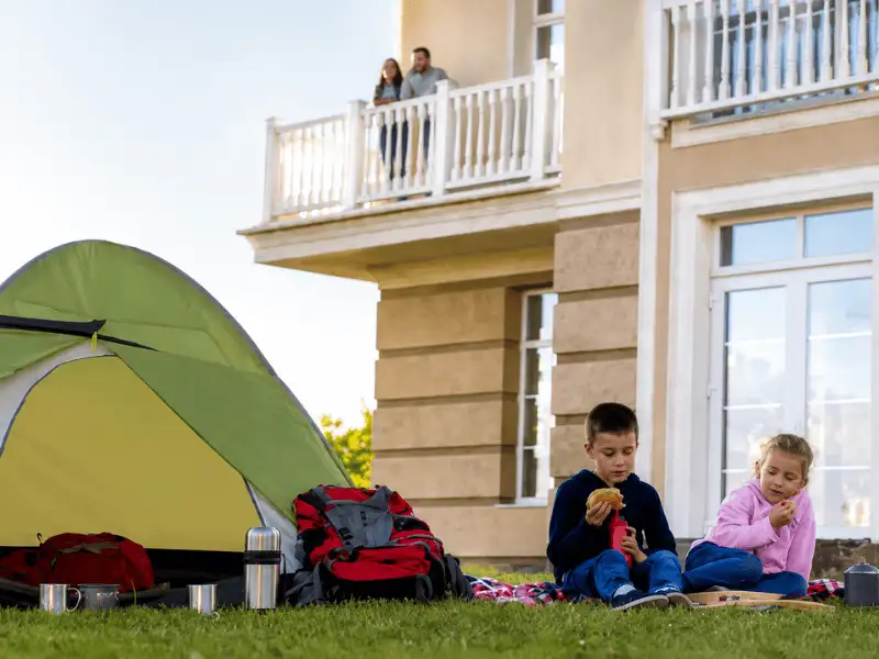 Children camping in the backyard of a family home representing homeowners insurance protection.