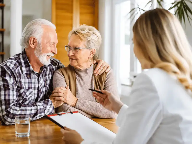 Senior couple discussing retirement and insurance planning with a professional advisor.